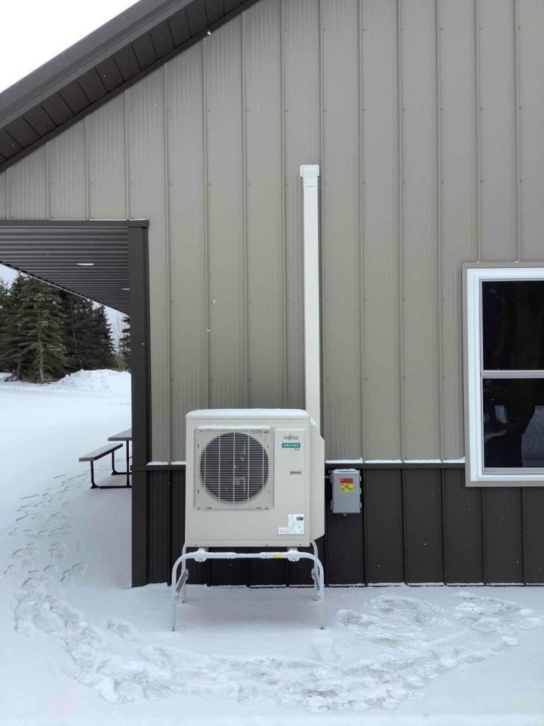 Fujitsu heat pump outside a home in winter